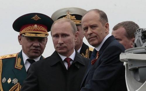 The featured photo shows  Russian President Vladimir Putin, center, flanked by Defense Minister Sergei Shoigu, left, and Federal Security Service Chief Alexander Bortnikov, right, arrives on a boat after inspecting battleships during a navy parade marking Victory Day in Sevastopol, Crimea. (AP Photo/Ivan Sekretarev, File) Friday, May 9, 2014